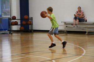 Young Boy Dribbling on the Basketball Court at The HUB Recreation Center