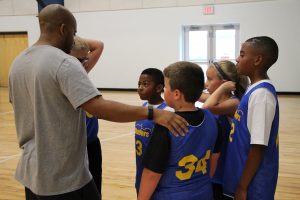 Young Boys and Girls Hudding with Basketball Coach at The HUB Recreation Center
