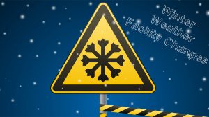 Yellow Street Sign with Snowflake in Front of Snowy Blue and White Background