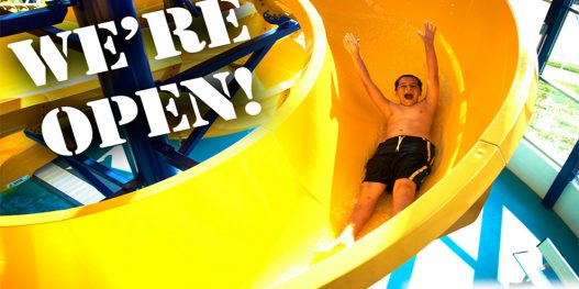 Boy Going Down the Waterslide with Arms in the Air